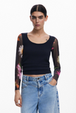 woman wearing t-shirt with floral mesh sleeves and solid black body