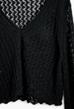 closer detail of sweater weave, showing trim on neck and scalloped edge of hem